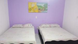 duas camas num quarto com uma fotografia na parede em Pousada Carimbó em Fortaleza