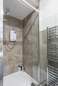 a bathroom with a shower with a glass door at Captivating 2 bedroom home with jacuzzi and conservatory in Hamilton