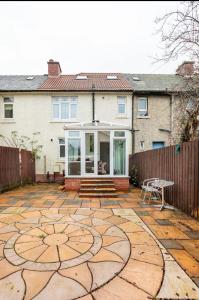 a house with a large stone patio with a building at Captivating 2 bedroom home with jacuzzi and conservatory in Hamilton