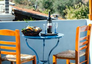 uma mesa com uma garrafa de vinho e uma cesta de frutas em Sunset Suite - Salamina Island em Salamina