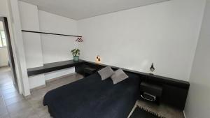 a bedroom with a black bed in a room at Casa J moderna con amplio jardín en barrio de profesionales in San Salvador de Jujuy
