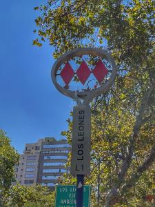 un letrero de la calle en un poste frente a un edificio en Apartamentos City Centro Los Leones, en Santiago