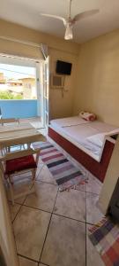 a bedroom with a bed and a table and a television at Suítes Praia Do Foguete in Cabo Frio