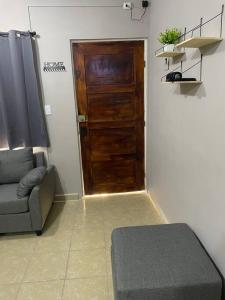 a living room with a wooden door and a couch at Departamento Relax en Tampico in Tampico