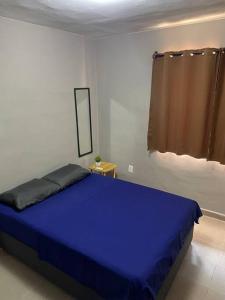 a blue bed in a white room with a window at Departamento Relax en Tampico in Tampico