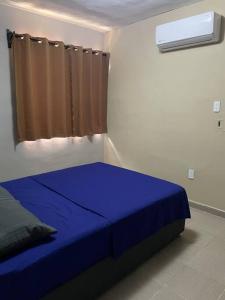 a blue bed in a room with a window at Departamento Relax en Tampico in Tampico