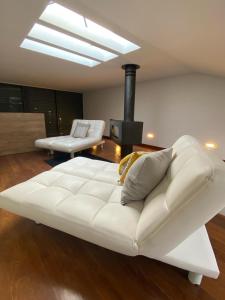 un divano bianco in un soggiorno con camino di Casa da Avenida VILLA INN a Braga