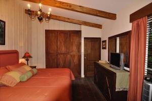 a bedroom with a bed and a flat screen tv at Cabin at Los Titos Coffee Farm 