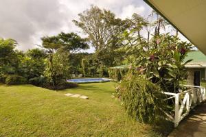 einen Garten mit einem Zaun und einem Pool in der Unterkunft Cabin at Los Titos Coffee Farm 