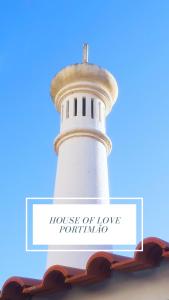 Un faro blanco con las palabras Casa del amor regresando en House of Love Portimão en Portimão