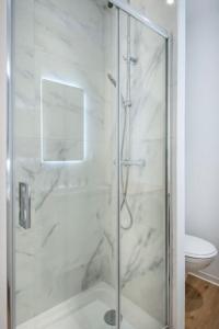 a shower with a glass door in a bathroom at Les Halles & Le port - Grand T2 haut de gamme in Toulon