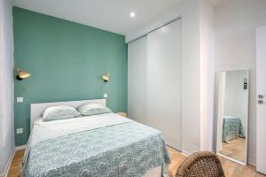 a bedroom with a bed and a blue wall at Les Halles & Le port - Grand T2 haut de gamme in Toulon