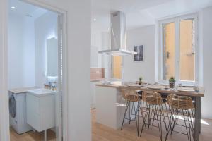 a kitchen with a counter with stools and a sink at Les Halles & Le port - Grand T2 haut de gamme in Toulon +5 photos