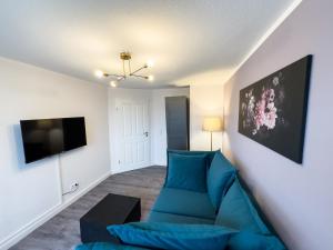 a living room with a blue couch and a flat screen tv at Messewohnung für 4 Gäste mit kostenlosem Parkplatz in Hannover