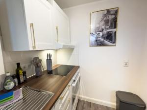 a kitchen with white cabinets and a wooden counter top at Messewohnung für 4 Gäste mit kostenlosem Parkplatz in Hannover