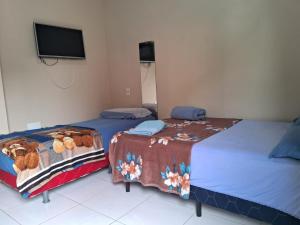 two beds sitting next to each other in a room at Edward Suíte Manaus 03 in Manaus