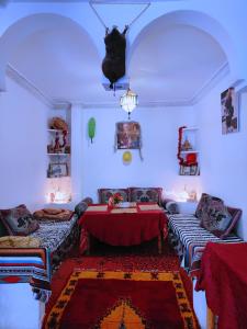 ein Wohnzimmer mit einem Tisch und einem Sofa in der Unterkunft Riad Kasbah des Roches in Akhendachou nʼAït Ouffi