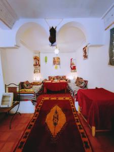 una sala de estar con 2 mesas y una alfombra en Riad Kasbah des Roches, en Akhendachou nʼAït Ouffi