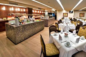a restaurant with tables and chairs and a buffet at Courtyard by Marriott Mexico City Revolucion in Mexico City