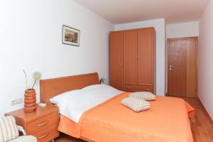 1 dormitorio con 1 cama y armario de madera en Apartment Maya, en Dubrovnik