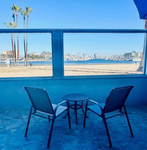 two chairs and a table in front of a beach at Foghorn Harbor Inn in Los Angeles