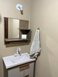 a bathroom with a sink and a mirror at casa ilha bela in Ilhabela