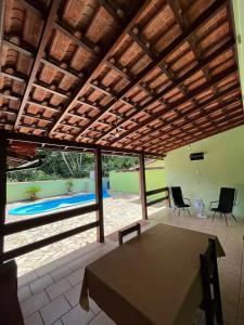 a patio with a table and chairs and a pool at casa ilha bela in Ilhabela