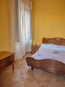 um quarto com uma cama grande e uma cabeceira em madeira em Peperoni House - Sea and Mountain Experience em San Marco Argentano