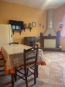uma sala de jantar com uma mesa e uma televisão em Peperoni House - Sea and Mountain Experience em San Marco Argentano