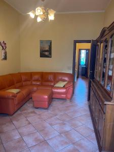 a living room with a brown leather couch at Peperoni House - Sea and Mountain Experience in San Marco Argentano