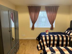 a bedroom with two beds and a window at Very Spacious Two Bedroom Apartment in Grays Thurrock