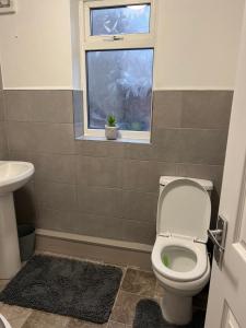 a bathroom with a toilet and a window at Very Spacious Two Bedroom Apartment in Grays Thurrock
