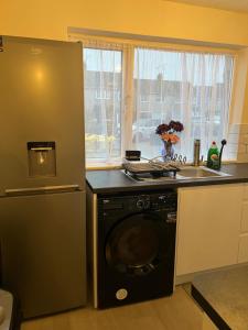 cocina con nevera y lavadora en Very Spacious Two Bedroom Apartment en Grays Thurrock
