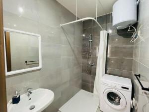 a bathroom with a sink and a washing machine at Coral Cove Comfort Room 1 in St. Paul's Bay