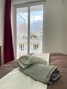 uma cama com toalhas por cima em frente a uma janela em Coral Cove Comfort Room 1 em St. Paul's Bay