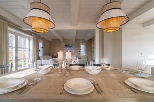 a dining room table with white plates and silverware at Antonias Hüs in Midlum