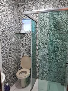 a bathroom with a toilet and a glass shower at Edward Suíte Manaus 03 in Manaus