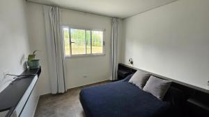 a bedroom with a blue bed and a window at Casa J moderna con amplio jardín en barrio de profesionales in San Salvador de Jujuy
