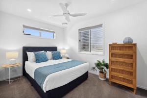 Un dormitorio con una cama y un ventilador de techo. en Aloha Allura, en Coolum Beach