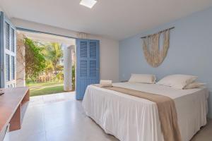 een slaapkamer met een bed en een blauwe deur bij Pousada Katavento #Q5 - Na Praia por Carpediem in Cumbuco