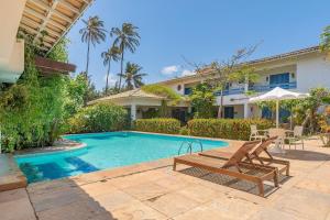 een zwembad met een bank en een huis bij Pousada Katavento #Q5 - Na Praia por Carpediem in Cumbuco