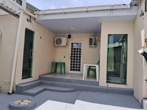 une maison avec une table verte et une porte dans l'établissement Edward Suíte Manaus 03, à Manaus