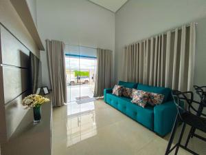 ein Wohnzimmer mit einem blauen Sofa und einem Fenster in der Unterkunft Casa butique veraneios 2 in Caldas Novas