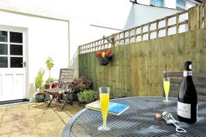 a bottle of wine sitting on a table with a glass at Vine Cottage in Charmouth