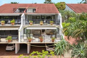 a large house with potted plants on the balcony at Bayona Apartment 2, Little Cove in Noosa Heads