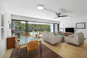 a living room with a glass table and a couch at Bayona Apartment 2, Little Cove in Noosa Heads