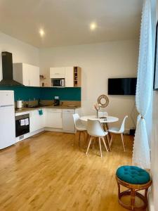 a kitchen and dining room with a table and chairs at Madini-Breizh :T3 cœur de ville in Lannion