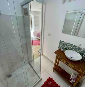 a bathroom with a shower and a sink and a mirror at Flat Espaçoso Inteiro Privativo! Alto da Boavista in São Paulo