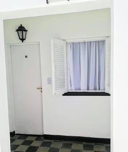 biały pokój z oknem i drzwiami w obiekcie Almirante Brown 49 w mieście Mar de Ajó