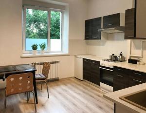 uma cozinha com uma mesa, um fogão e uma janela em Mieszkanie Centrum 60 m na wylacznosc em Lublin